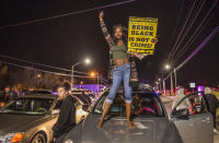 <p>Kianshay Brown of Sacramento stands on a car on Meadoview Rd. as she joined participants of a candlelight vigil in honor of Stephon Clark who marched to the area near where Clark was shot at his grandparents home in Sacramento, Calif., on March 23, 2018. (Photo: Hector Amezcua/Sacramento Bee via ZUMA Wire) </p>