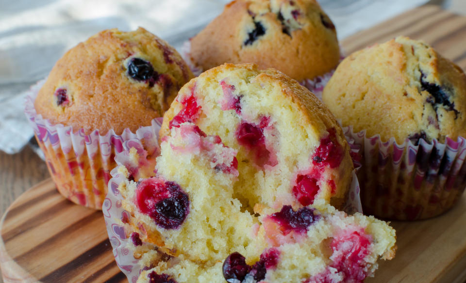 Muffins with red and black currant paper bakeware with Valentine's day design with pink hearts