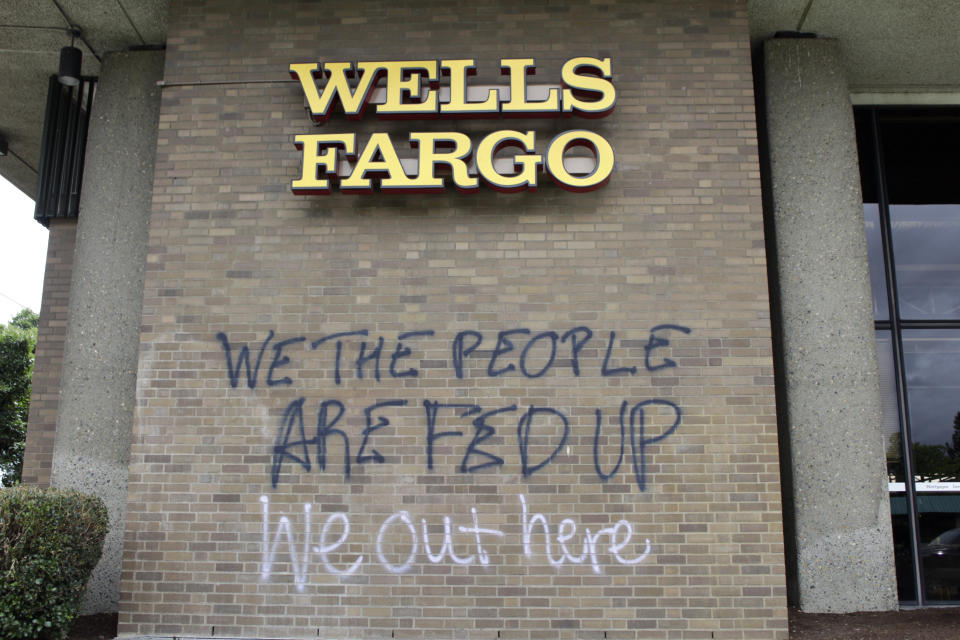 Graffiti covers the exterior of a Wells Fargo bank on Wednesday, July 1, 2020, in a historically Black neighborhood in Portland, Ore., that has been the scene of violent clashes with police in recent days. Thousands of protesters in the liberal and predominantly white city have taken to the streets peacefully every day for more than five weeks to decry police brutality, but recent violence by smaller groups is creating a deep schism in the protest movement. As demonstrations enter their second month, they have shifted to a historically Black neighborhood in North Portland. (AP Photo/Gillian Flaccus)