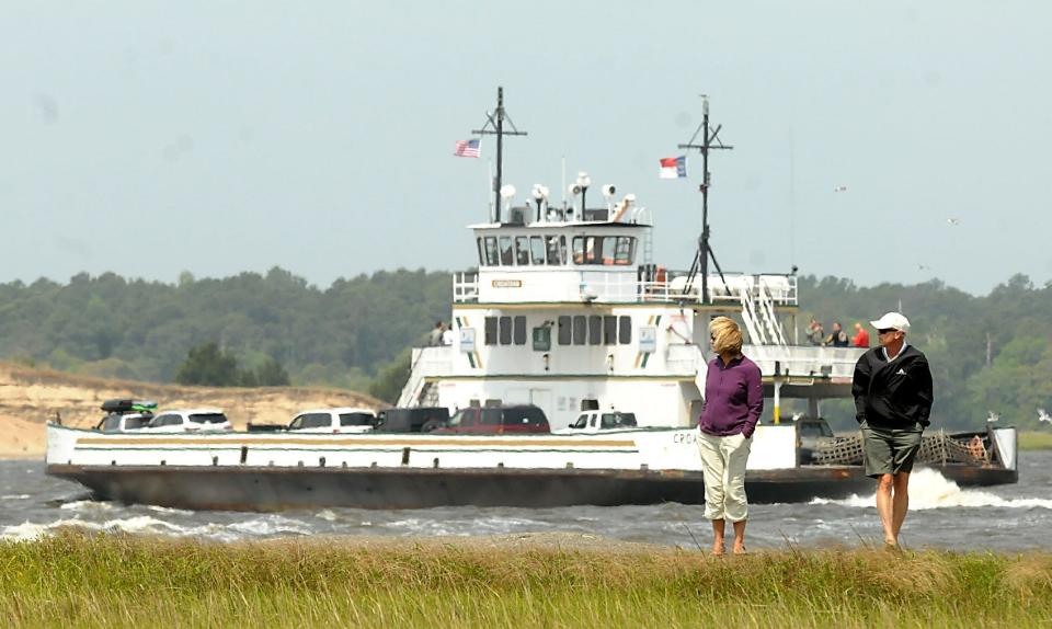 Hal and Terry Shortsleeve walk along the jetty at the southern end of Fort Fisher as the Fort Fisher-Southport ferry passes by. KEN BLEVINS/STARNEWS