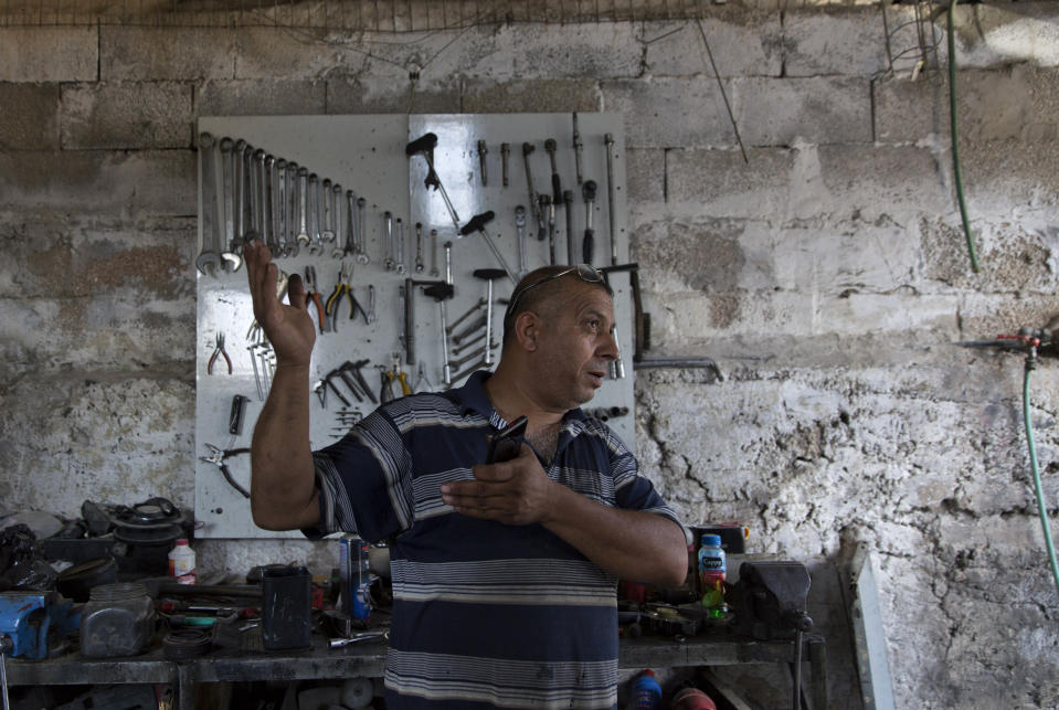 In this Wednesday, Sept. 11, 2019 photo, Palestinian Barhoum Saleh gives an interview at his roadside mechanic shop, near the West Bank Israeli settlement of Elkana, west of Qalqiliya. Saleh is among the 2.5 million Palestinians in the West Bank who have no voice in choosing Israel’s next government and no control over whether it decides to annex part or all of the occupied territory, as Prime Minister Benjamin Netanyahu has vowed to do. (AP Photo/Nasser Nasser)