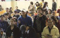 Parents search for their children's names among a list of survivors rescued from a ferry that sank off the country's southern coast, at Danwon high school in Ansan, South Korea, Wednesday, April 16, 2014. Dozens of boats, helicopters and divers scrambled to rescue more than 470 people, including 325 students on a school trip from the high school, after the ship sank earlier in the day. (AP Photo/Ahn Young-joon)