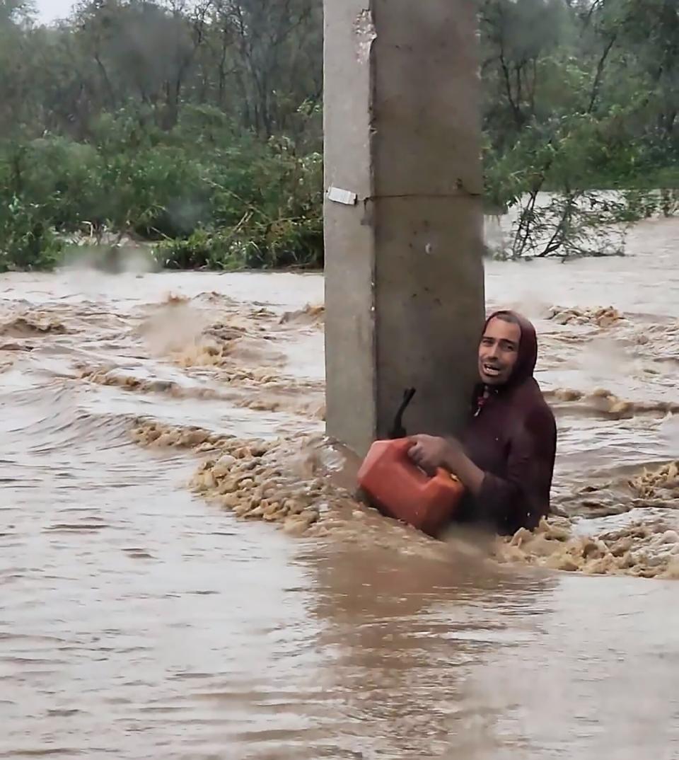 man clings to a concrete beam in Ponce, Puerto Rico during flooding