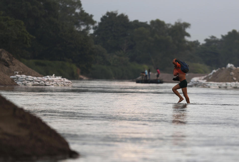 A migrant walks across the Suchiate River from Guatemala into Mexico, near Ciudad Hidalgo, Chiapas State, Mexico, Friday, Jan. 17, 2020. United States officials are crediting tough measures taken over the past year and cooperation from regional governments for sharply reducing the number of Central American migrants who responded to a call for a new caravan. (AP Photo/Marco Ugarte)