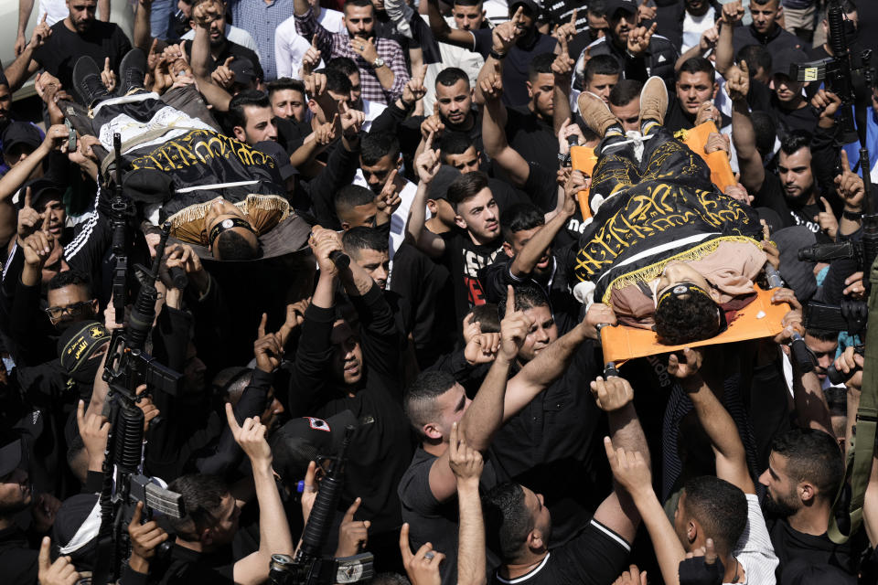 Mourners carry the bodies of Ahmed Assaf, 19, right, and Rani Qatanat, 24, left, draped in the flag of Islamic Jihad, two Palestinians killed by Israeli forces in Qabatiya, near the West Bank city of Jenin, Wednesday, May 10, 2023. The Israeli military said that Palestinian gunmen opened fire at troops in the Palestinian town of Qabatiya in the northern West Bank during an army raid. Troops returned fire, killing the two men, and confiscated their firearms, it said. (AP Photo/Majdi Mohammed)