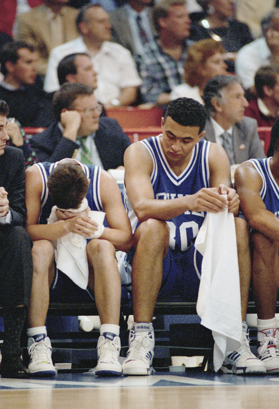 FILE - Duke's Bobby Hurley, left, and teammate Alaa Abdelnaby sit dejectedly on the bench as their team gets run over by UNLV 103-73 in the championship game of the Final Four Monday, April 2, 1990 in Denver. (AP Photo/Eric Risberg, File)