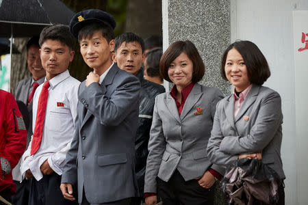 College students from the Wonsan Agricultural University in Wonsan, North Korea, shelter from the rain under a university building October, 2016. Christian Peterson-Clausen/Handout via REUTERS