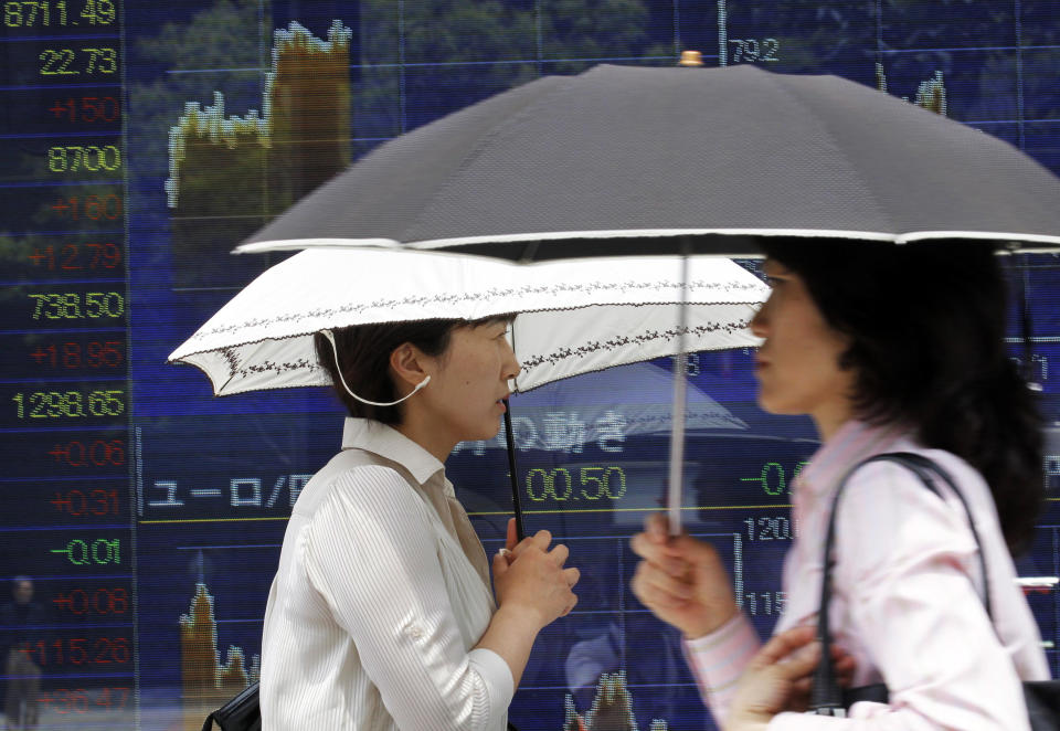 People walk by an electronic stock board of a securities firm in Tokyo, Monday, June 18, 2012. Asian stock markets climbed Monday after elections in Greece eased fears of global financial turmoil, but analysts warned that the economic crisis shaking the 17 nations in the euro common currency was far from over. Tokyo's benchmark Nikkei 225 index was up 1.8 percent at 8,721.41. (AP Photo/Koji Sasahara)