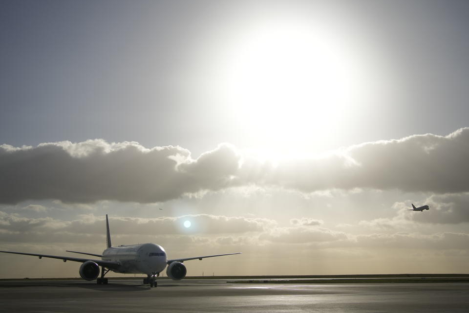 FILE - An Air France plane, left, rolls on the tarmac as a plane takes off at the Charles de Gaulle airport, north of Paris, Monday, Nov. 8, 2021. Several countries and companies plan to accelerate the switch to emissions-free ground, air and sea transport at part of efforts to curb global warming. (AP Photo/Christophe Ena, File)