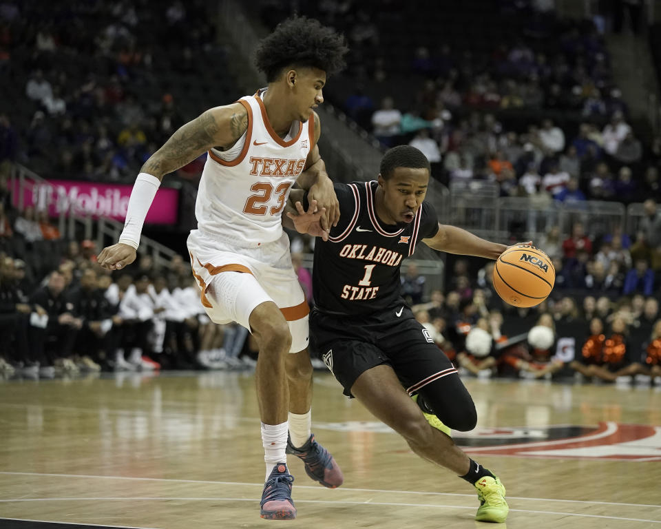 Oklahoma State guard Bryce Thompson (1) drives under pressured by Texas forward Dillon Mitchell (23) during the first half of an NCAA college basketball game in the second round of the Big 12 Conference tournament Thursday, March 9, 2023, in Kansas City, Mo. (AP Photo/Charlie Riedel)
