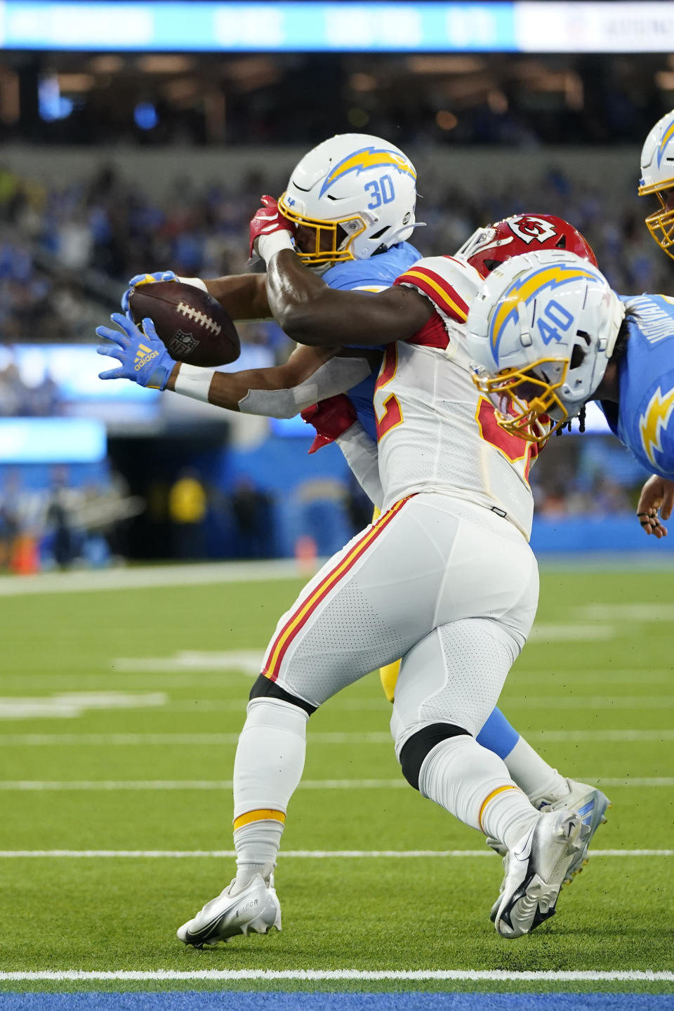 Los Angeles Chargers running back Austin Ekeler, left, scores a touchdown as he is face masked by Kansas City Chiefs linebacker Nick Bolton during the first half of an NFL football game Sunday, Nov. 20, 2022, in Inglewood, Calif. (AP Photo/Jae C. Hong)