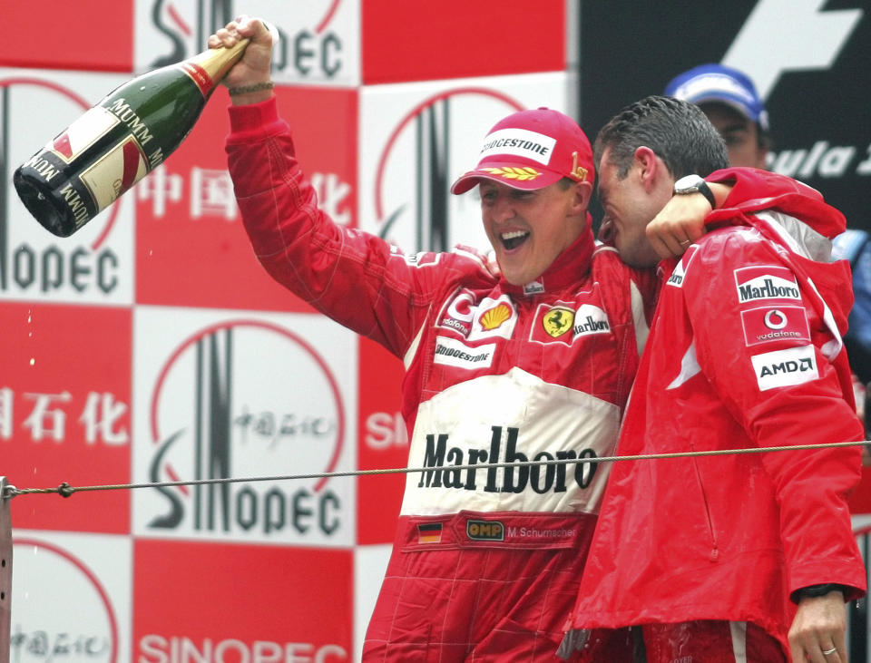 FILE - In this Sunday Oct. 1, 2006 file photo, Germany's Michael Schumacher, left, celebrates his win in the Formula One Chinese Grand Prix with race engineer Chris Dyer, at the Shanghai International Circuit in Shanghai, China. British driver Lewis Hamilton made Formula One history on Sunday, Oct. 25, 2020 winning the Portuguese Grand Prix for a 92nd win to move one ahead of German great Michael Schumacher. (AP Photo/Greg Baker, file)