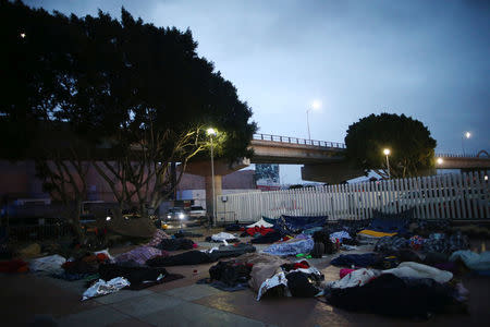 Members of a caravan of migrants from Central America sleep near the San Ysidro checkpoint after a small group of fellow migrants entered the United States border and customs facility, where they are expected to apply for asylum, in Tijuana, Mexico April 30, 2018. REUTERS/Edgard Garrido