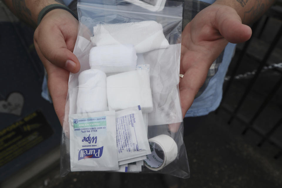 Iris Sidikman, harm reduction coordinator at the Women's Health Center of West Virginia, holds a wound care kit the clinic has on hand for intravenous drug users seeking care in the clinic parking lot on Thursday, Aug. 4, 2023, in Charleston, W.Va. (AP Photo/Leah Willingham)