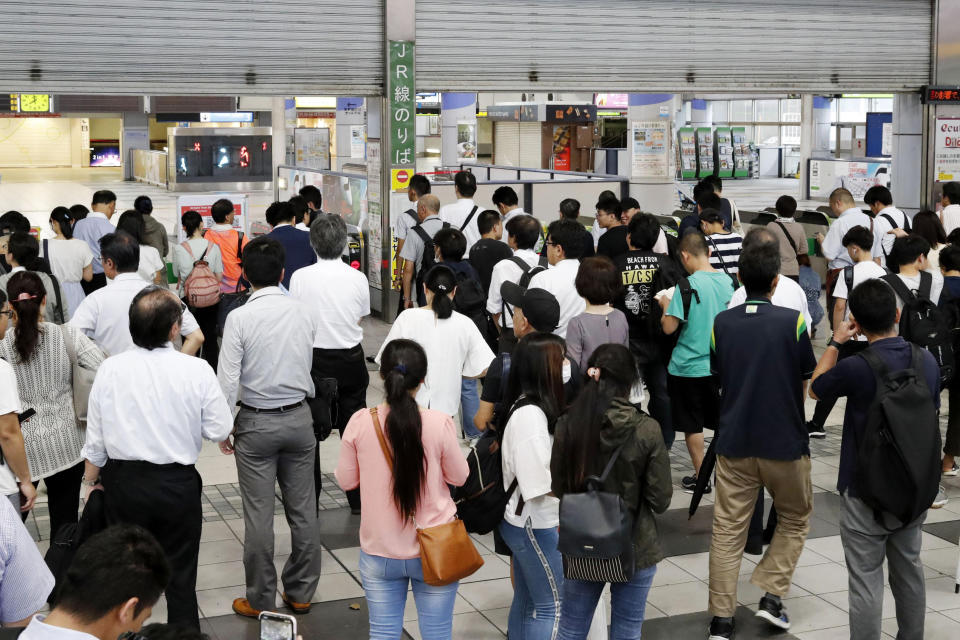 Commuters wait at a station as train operation is suspended due to typhoon in Tokyo, Monday, Sept. 9, 2019, in Tokyo. (Kyodo News via AP)