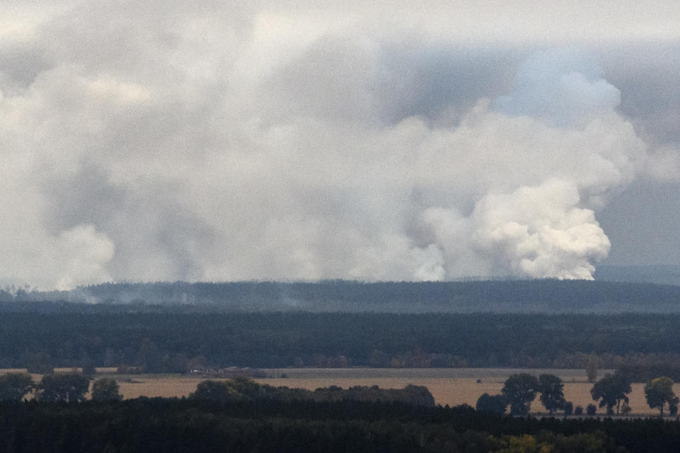 Smoke rises after a powerful explosion at the ammunition depot of a military base near the town of Ichnya, about 170 km (110 mile) east of Kiev Ukraine, early Tuesday, Oct. 9, 2018. More than 10,000 residents have been evacuated after an ammunition depot exploded early Tuesday. (Vlad Musienko /Prime Minister Service Pool Photo via AP)