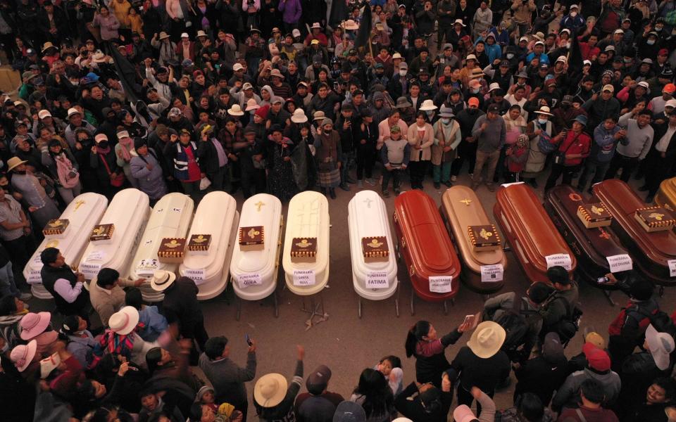 Relatives stand around empty coffins waiting for the delivery of the dead outside the Carlos Monje Medrano Hospital, in Juliaca, Peru - EPA-EFE/Shutterstock