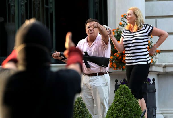 PHOTO: Mark and Patricia McCloskey stand in front their house as they confront protesters marching to St. Louis Mayor Lyda Krewson's house, June 28, 2020. (St. Louis Post-Dispatch/Tribune News Service via Getty Images)