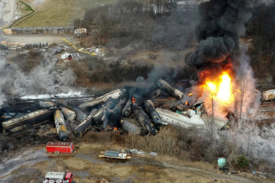 FILE - Portions of a Norfolk Southern freight train that derailed the night before burn in East Palestine, Ohio, Feb. 4, 2023. The White House says President Joe Biden will visit the eastern Ohio community that was devastated by a fiery train derailment in February 2023. (AP Photo/Gene J. Puskar, File) ORG XMIT: WX101