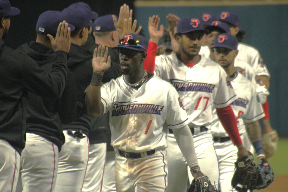 Left fielder Jonathan Davis (1) and Jacksonville Jumbo Shrimp teammates celebrate their Opening Day win.