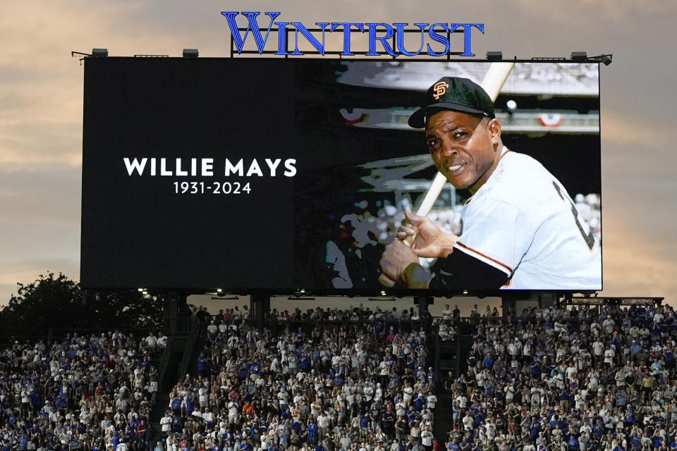 Fans stand for a moment of silence for former MLB player Willie Mays during the sixth inning of a baseball game between the San Francisco Giants and the Chicago Cubs in Chicago, Tuesday, June 18, 2024. (AP Photo/Nam Y. Huh)