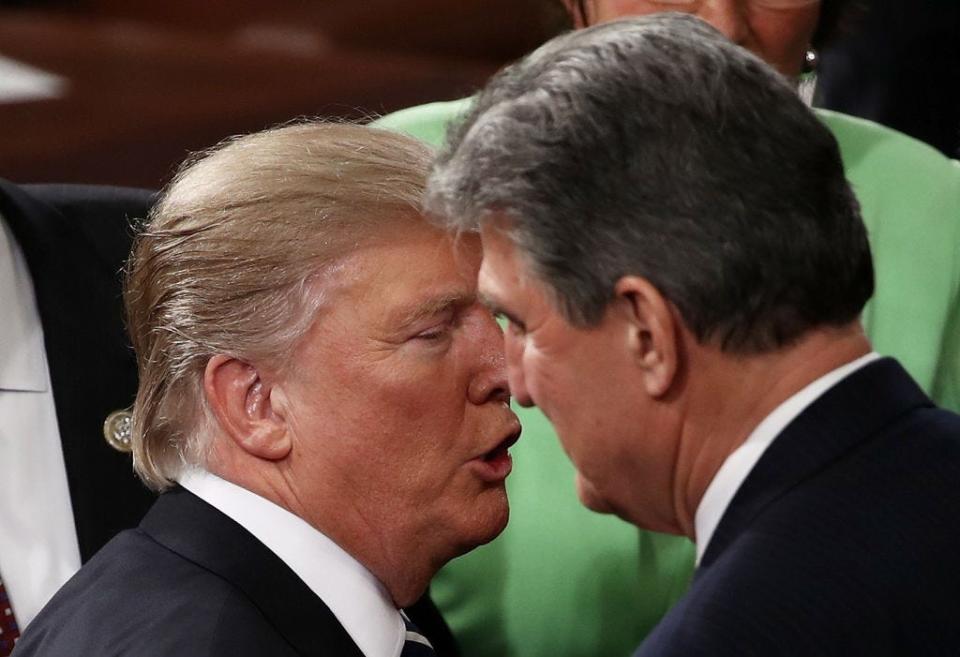 President Donald Trump speaks with Sen. Joe Manchin after addressing a joint session of Congress on Feb. 28, 2017.