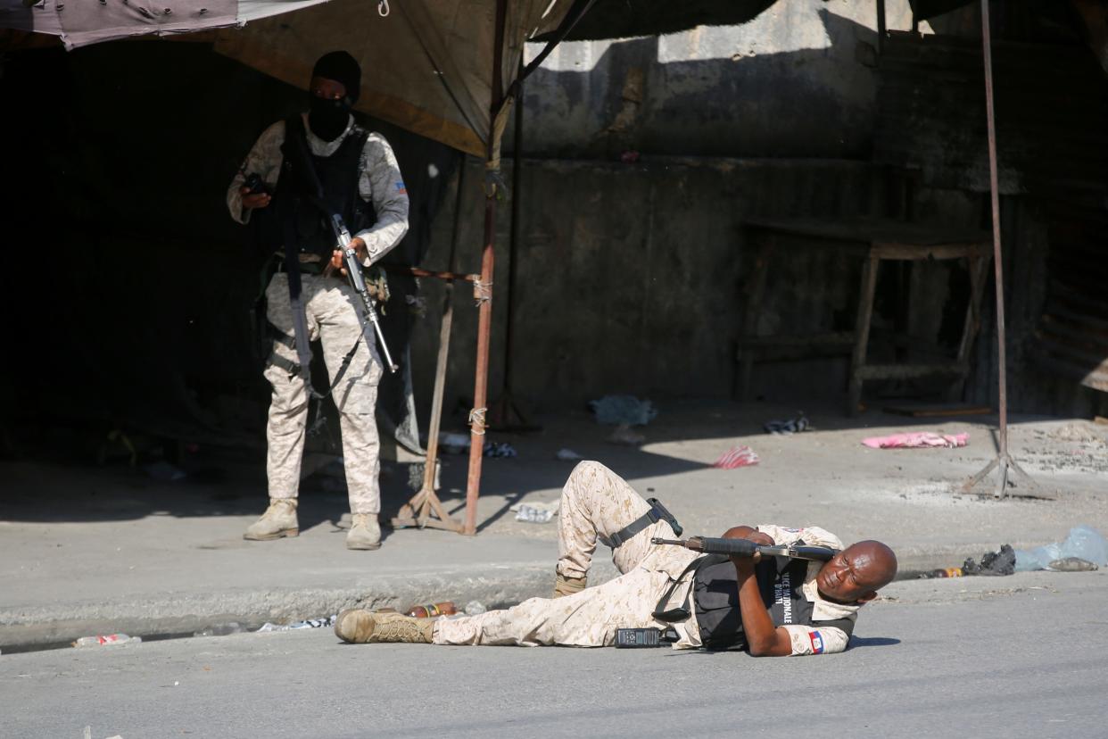 A police officer aims a weapon during clashes with gang members in Port-au-Prince, Haiti, on March 1, 2024.