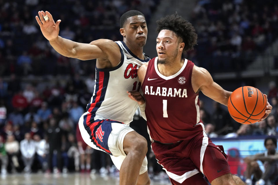 Alabama guard Mark Sears (1) dribbles past the defense of Mississippi guard Matthew Murrell (11) during the first half of an NCAA college basketball game, Wednesday, Feb. 28, 2024, in Oxford, Miss. (AP Photo/Rogelio V. Solis)