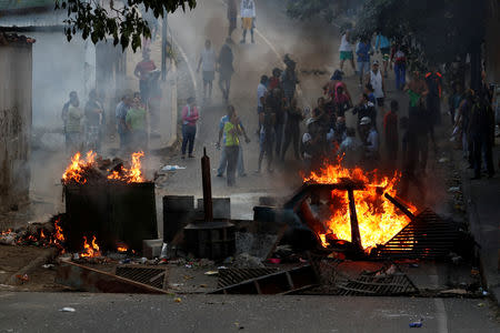 Demonstrators stand behind a burning barricade during a protest close to a National Guard outpost in Caracas, Venezuela January 21, 2019. REUTERS/Carlos Garcia Rawlins