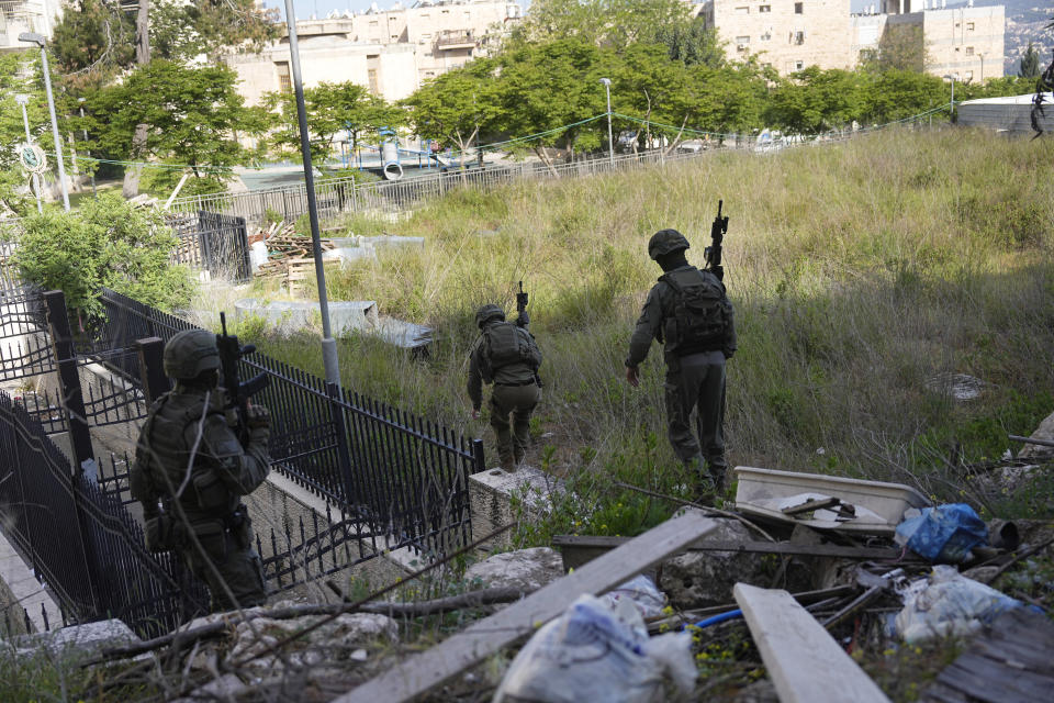 Israeli forces pursue suspected attackers in a ramming attack that wounded three people on the eve of the Jewish holiday of Passover, in Jerusalem, Monday, April 22, 2024. Israeli police say a car slammed into pedestrians in Jerusalem on Monday, wounding three people lightly in an apparent attack.(AP Photo/Ohad Zwigenberg)