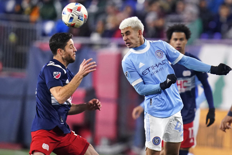 New York City midfielder Santiago Rodriguez, right, heads the ball over New England Revolution midfielder Matt Polster, left, during the first half of an MLS playoff soccer match, Tuesday, Nov. 30, 2021, in Foxborough, Mass. (AP Photo/Charles Krupa)