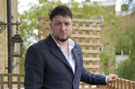 Dominic Watters, a single dad and founder of the Food is Care campaign, poses for a photograph outside his home in Canterbury, England, Monday, June 10, 2024. Since calling a general election, British Prime Minister Rishi Sunak has been at pains to repeat a key message on the campaign trail: The economy is turning a corner, inflation is down, and things are looking up. That’s not the reality for millions across the U.K. still feeling the squeeze from high food, energy and housing prices. (AP Photo/Kin Cheung)