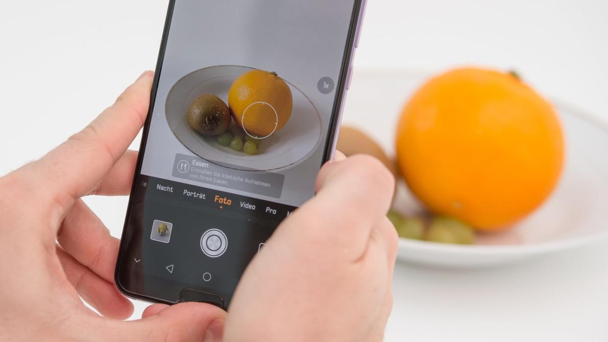 Die Künstliche Intelligenz in diesem Huawei Smartphone erkennt die Orange und richtet die Kamera für ein ansprechendes Food-Foto ein. Foto: Robert Günther/dpa-tmn