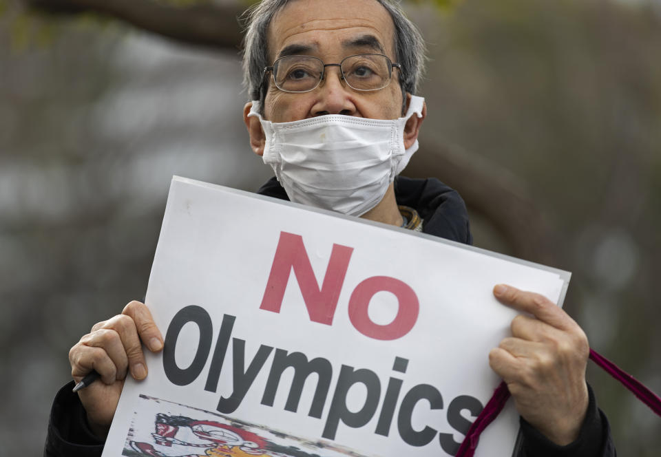 FILE - In this Feb. 12, 2021, file photo, a demonstrator holds a sign protesting the planned Tokyo 2020 Olympic games near a building where Yoshiro Mori was meeting to announce his resignation as the president of the Tokyo Olympic Organizing Committee in Tokyo. Mori stepped down two months ago after making derogatory comments about women. (AP Photo/Hiro Komae, File)