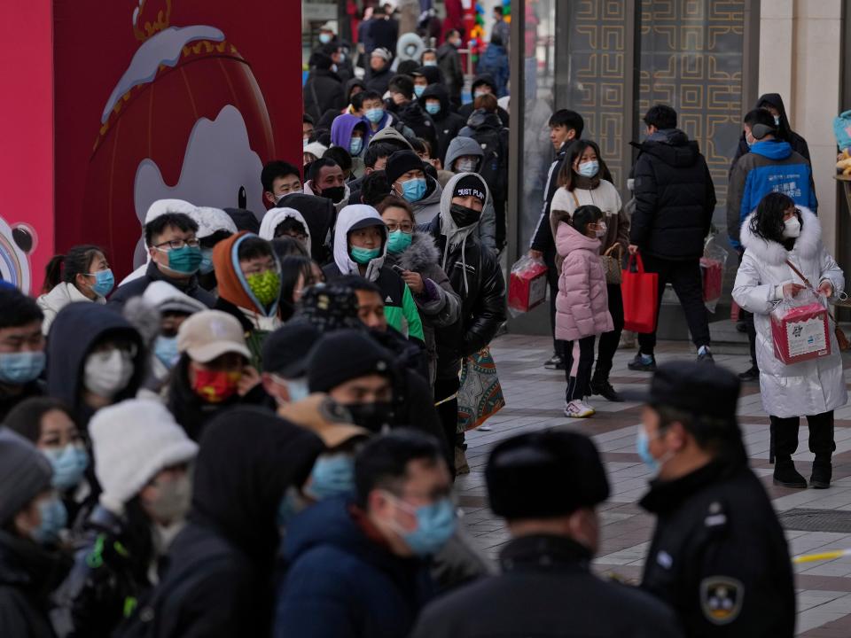 Hundreds of people line up to visit a store selling 2022 Winter Olympics memorabilia in Beijing, Monday, Feb. 7, 2022. The race is on to snap up scarce 2022 Winter Olympics souvenirs. Dolls of mascot Bing Dwen Dwen, a panda in a winter coat, sold out after buyers waited in line overnight in freezing weather.
