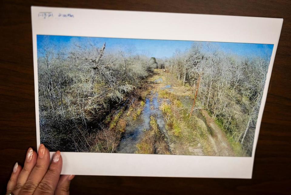 Kim Click, general manager of the Lake Livingston Water Supply, flips through photos of the flooding around the Trinity River at the water supply office on June 27, 2023.                                                                                                                          