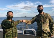 Lieutenant General Kevin Schneider, commander of U.S. Forces Japan, and General Koji Yamazaki, Japan's top military commander of Chief of Staff of Joint Staff greet each other on the destroyer JS Kaga at mid-sea off south of Japan