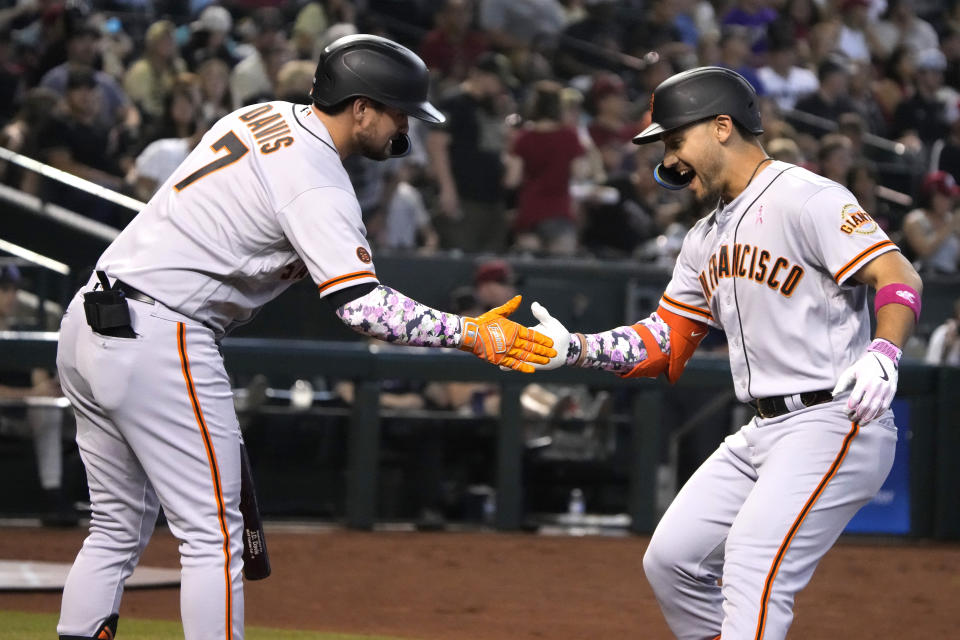 San Francisco Giants' Michael Conforto, right, celebrates with J.D. Davis (7) after hitting a solo home run against the Arizona Diamondbacks in the fourth inning during a baseball game, Sunday, May 14, 2023, in Phoenix. (AP Photo/Rick Scuteri)