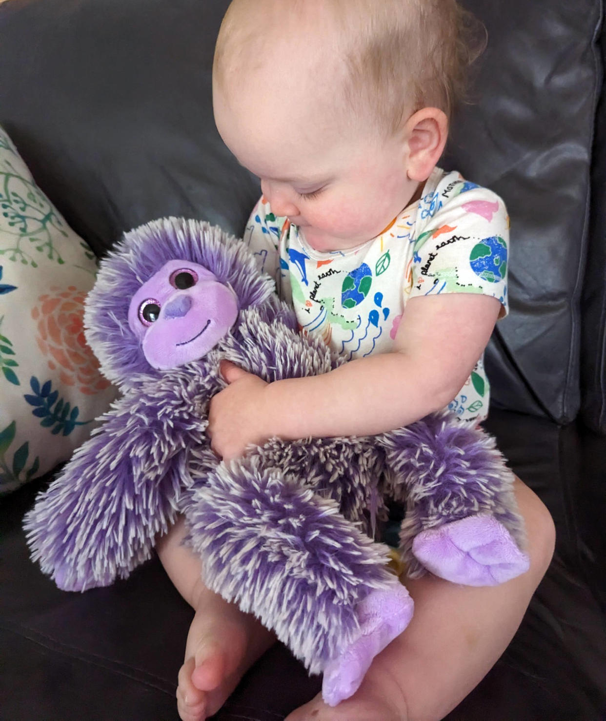 Charlie's daughter, Penelope, hugs the purple monkey his wife made. (Courtesy Charlie Willis)