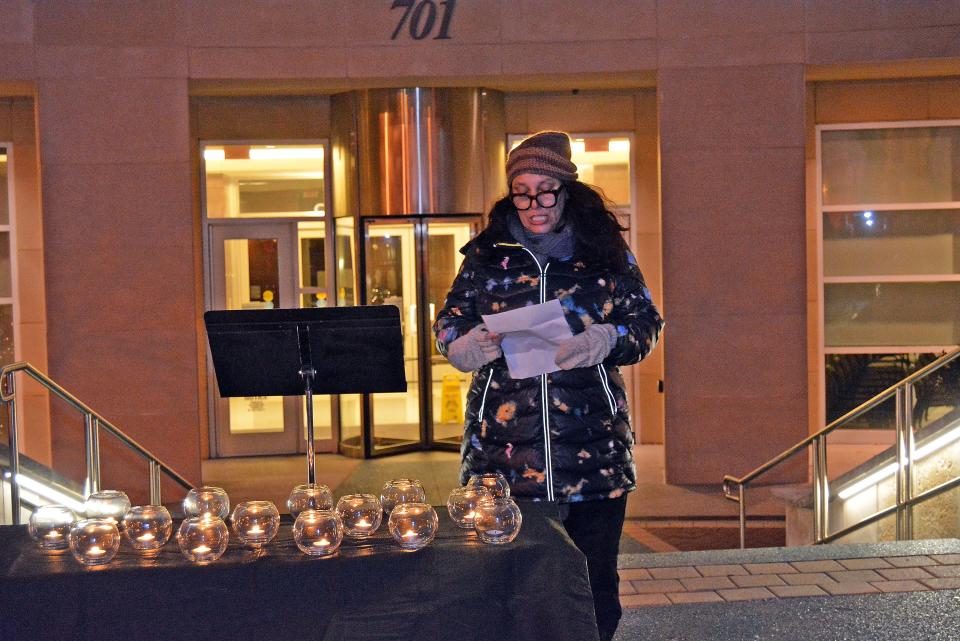 Catherine Arbrust with CoMo Mobile Aid Collective reads a message Wednesday during a memorial service for Columbia's unsheltered residents who died in 2022. The 15 candles on the table represent each of the lives lost. 