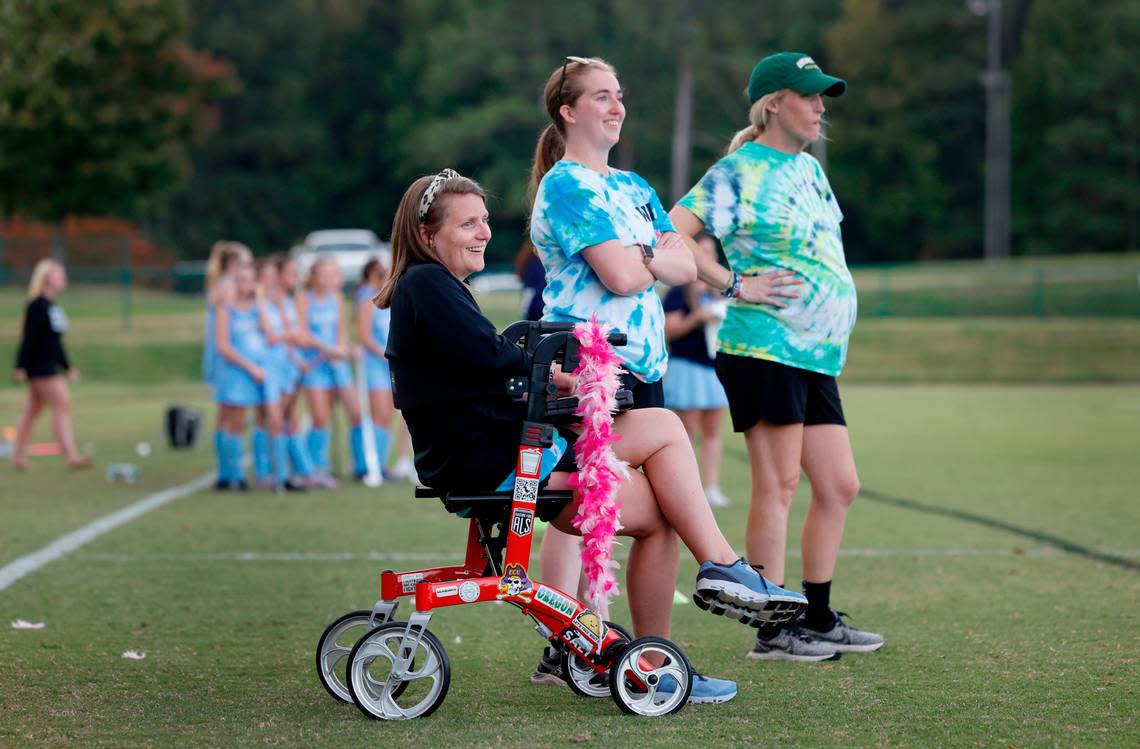 Ravenscroft High School field hockey coaches Whitford Wooten, left, Sydney Rameyan, center, and Meegan Hornan watch the team’s game against St. Mary’s School in Raleigh, N.C., Tuesday, Oct. 10, 2023. Wooten has ALS (amyotrophic lateral sclerosis or Lou Gehrig’s disease), a progressive neurodegenerative disease.