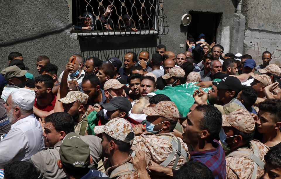 Palestinian mourners carry the body of Osama Dueij, 32, who was shot in the leg on Saturday during a violent demonstration on the northern border between Gaza and Israel, during his funeral in front of his family house in Jebaliya refugee camp, northern Gaza Strip, Wednesday, Aug. 25, 2021. (AP Photo/Adel Hana)