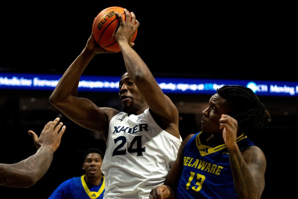 Xavier Musketeers forward Abou Ousmane (24) grabs a rebound over Delaware Blue Hens forward Jyare Davis (13) in the first half of the NCAA basketball game between the Delaware Blue Hens and the Xavier Musketeers at the Cintas Center in Cincinnati on Tuesday, Dec. 5, 2023.