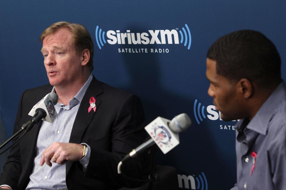 NFL Commissioner Roger Goodell, left, talks while former New York Giants defensive end Michael Strahan, right, and football fans listen during a Sirius XM Town Hall event in New York, Monday, Oct. 22, 2012. (AP Photo/Seth Wenig)