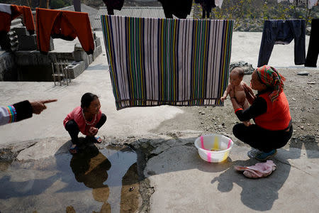 An ethnic Lisu woman baths her daughter in Fugong township in Nujiang Lisu Autonomous Prefecture in Yunnan province, China, March 25, 2018. REUTERS/Aly Song