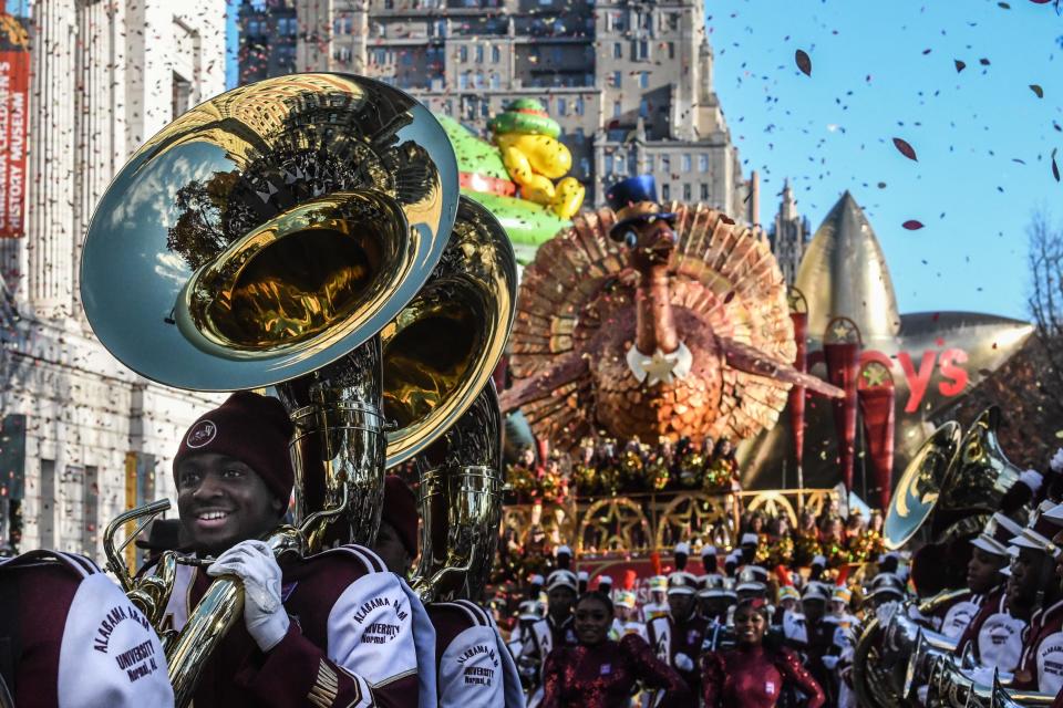 Parade performers lead the Tom Turkey float down Central Park West on a clear day in NYC