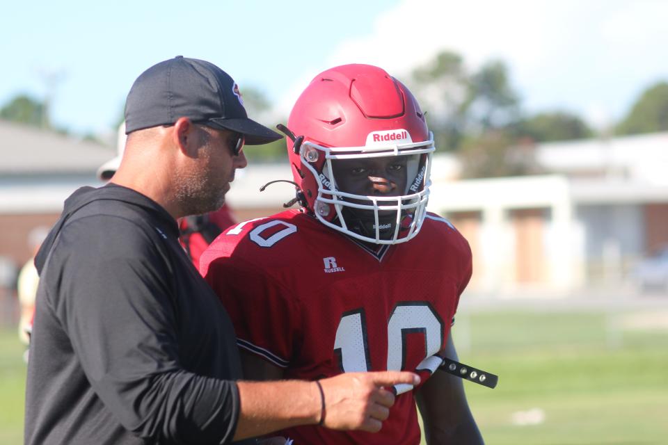 Jacksonville quarterback Jai'kei Taylor talks with offensive coordinator Steve Brooks during a recent practice.