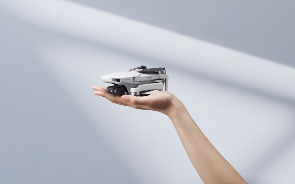 DJI's new Mini SE2 drone sitting on someone's palm. 