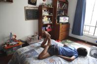 In this March 20, 2020 photo, Luka Espinoza watches TV in his room in Lima, Peru, during a lockdown due to the new coronavirus. For the upper-middle class, Lima’s 15-day quarantine hasn’t been too disruptive. (AP Photo/Martin Mejia)