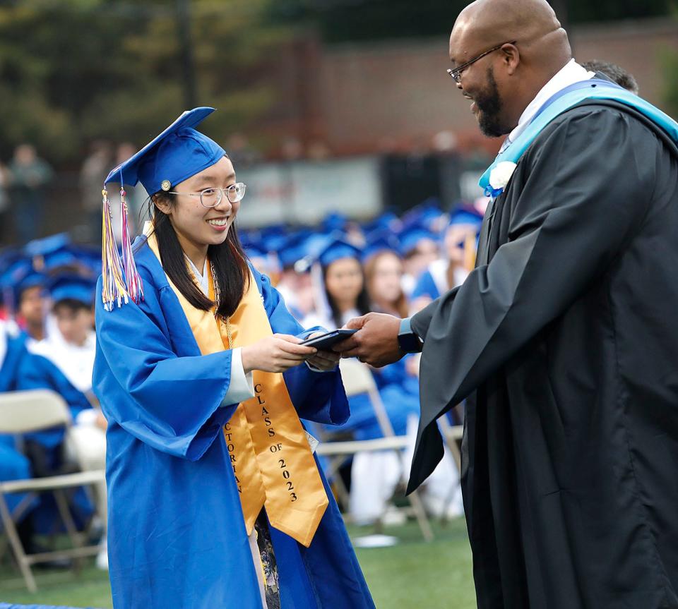 Valedictorian Christiana Nguyen receives her diploma from Principal Keith Ford during Quincy High School's commencement ceremonies at Veterans Stadium on Monday, June 5, 2023. She will attend MIT in the fall.